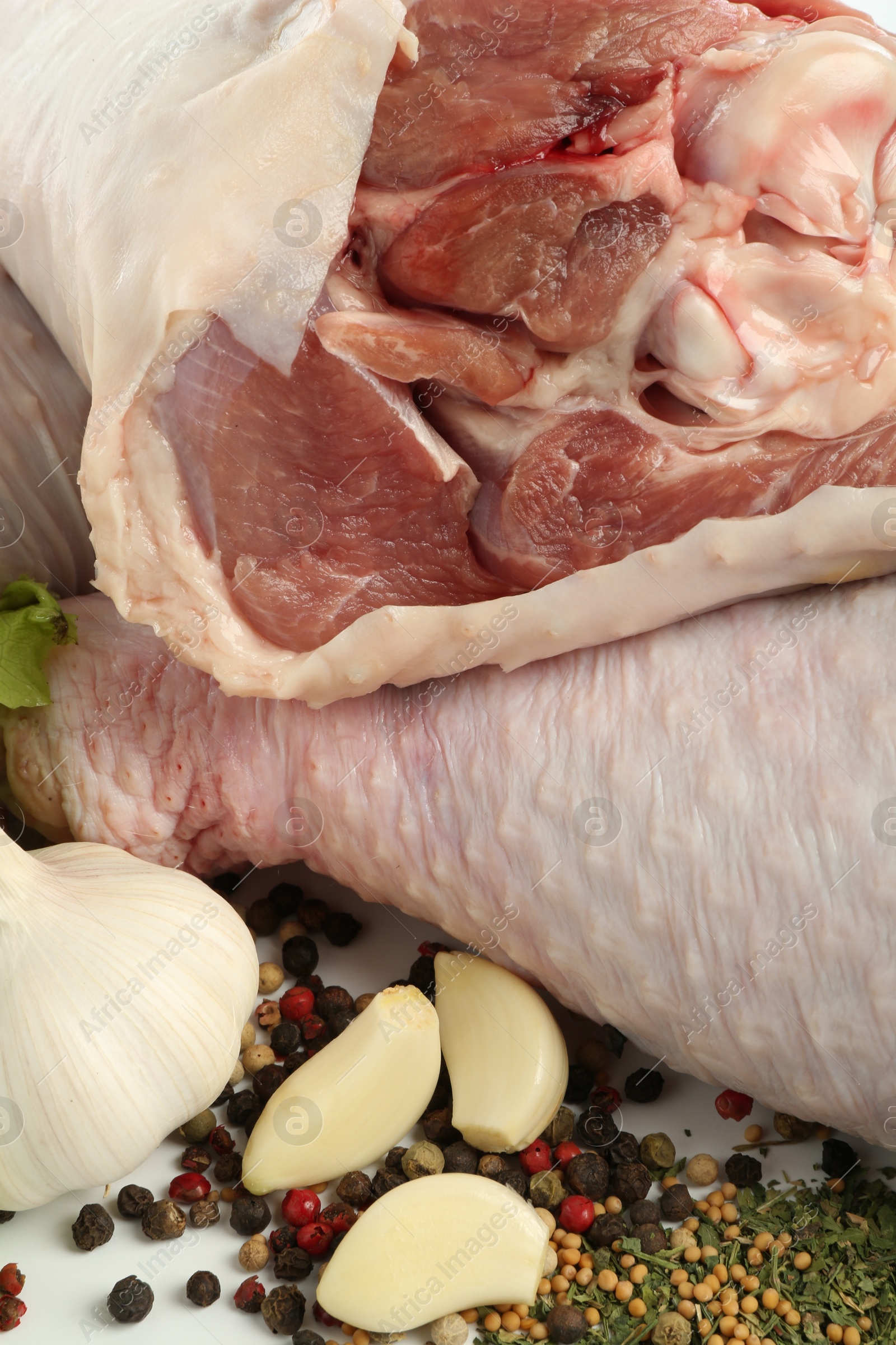 Photo of Raw turkey drumsticks and spices on table, closeup