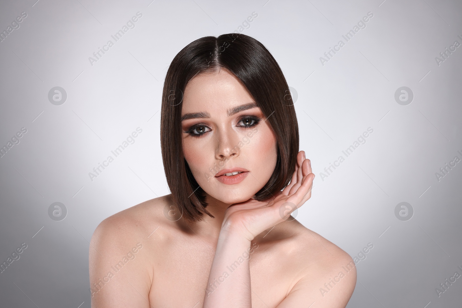 Photo of Portrait of beautiful young woman with gorgeous straight hair on light grey background