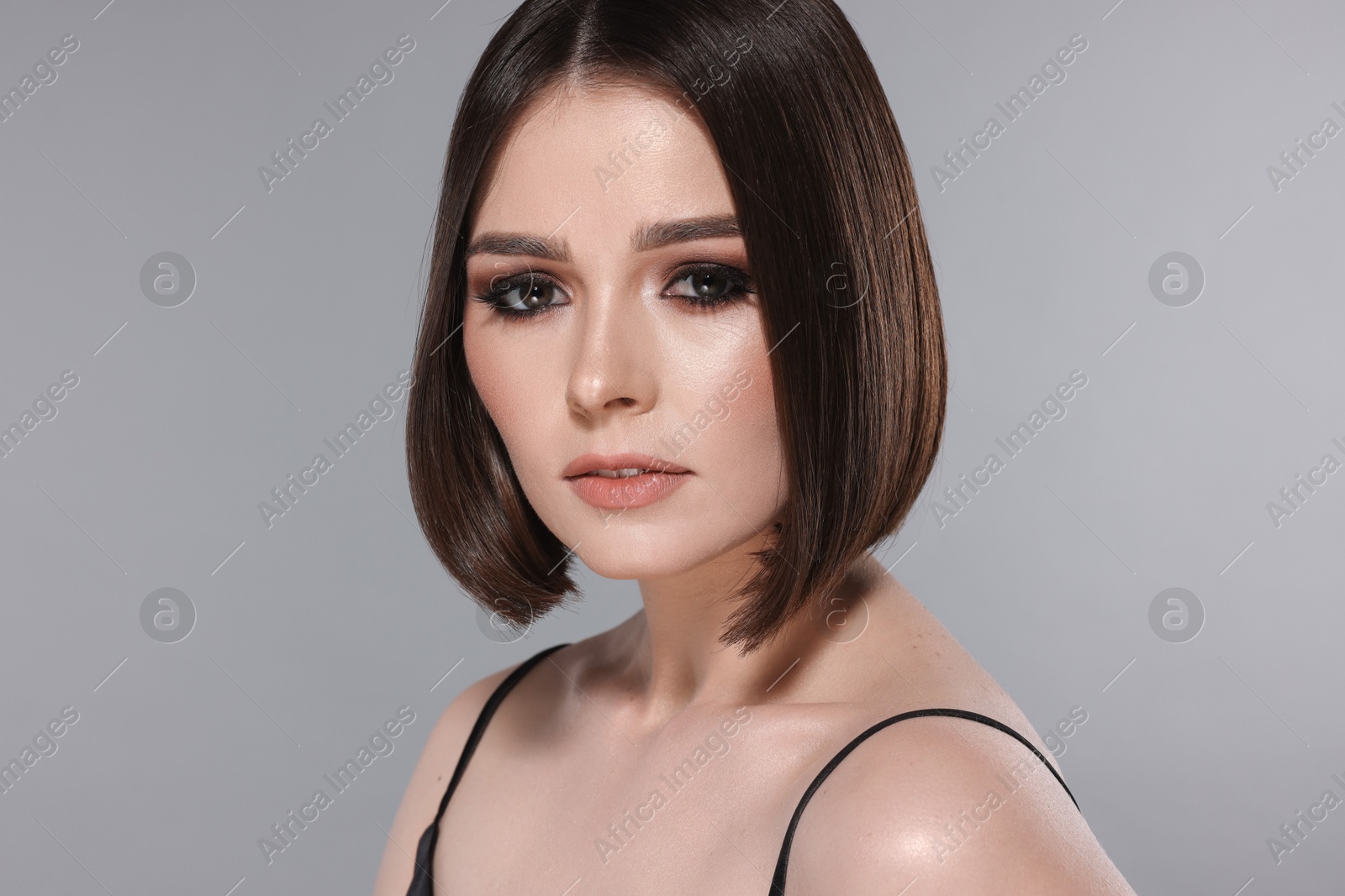 Photo of Portrait of beautiful young woman with gorgeous straight hair on light grey background