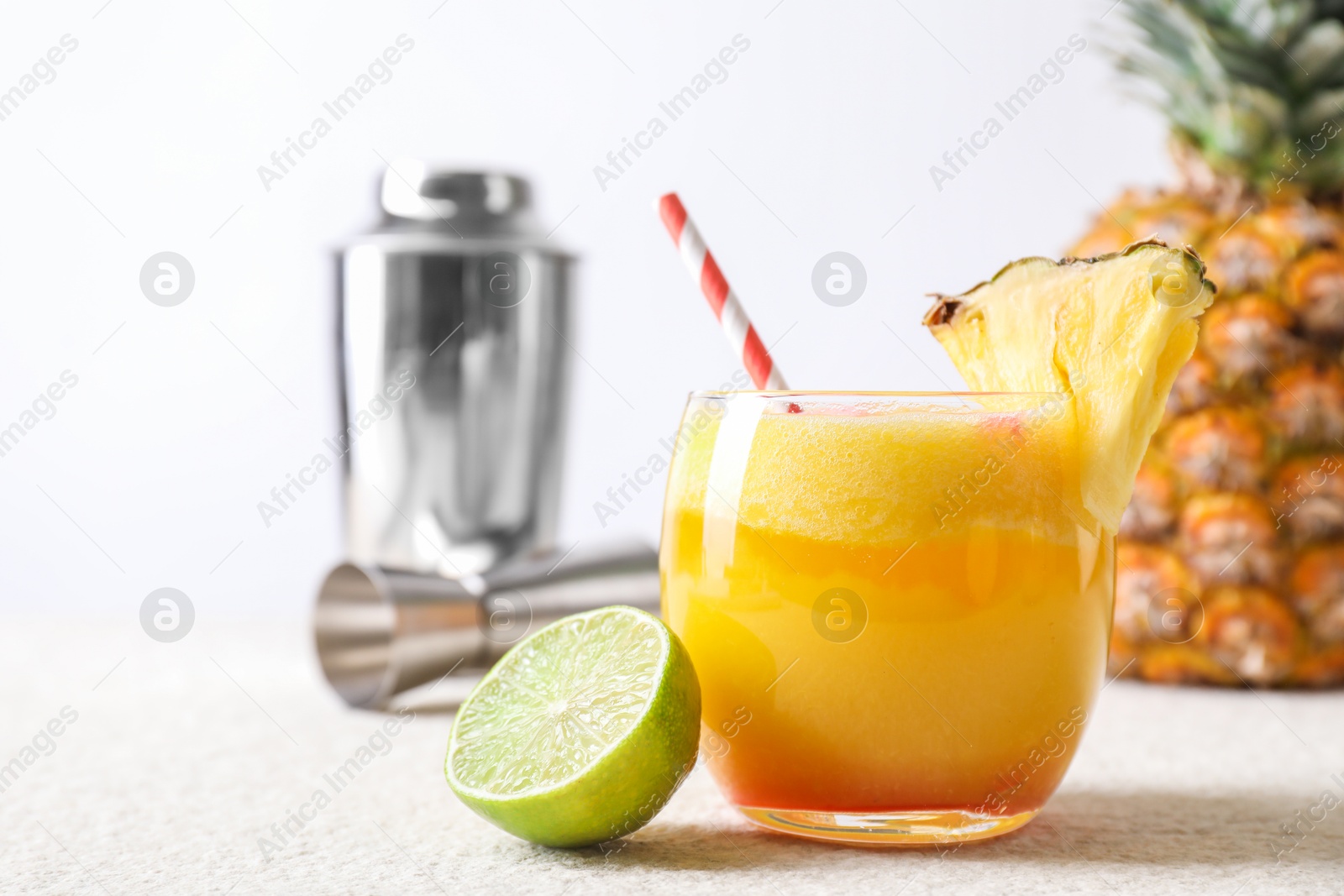 Photo of Tasty pineapple cocktail in glass served on white table