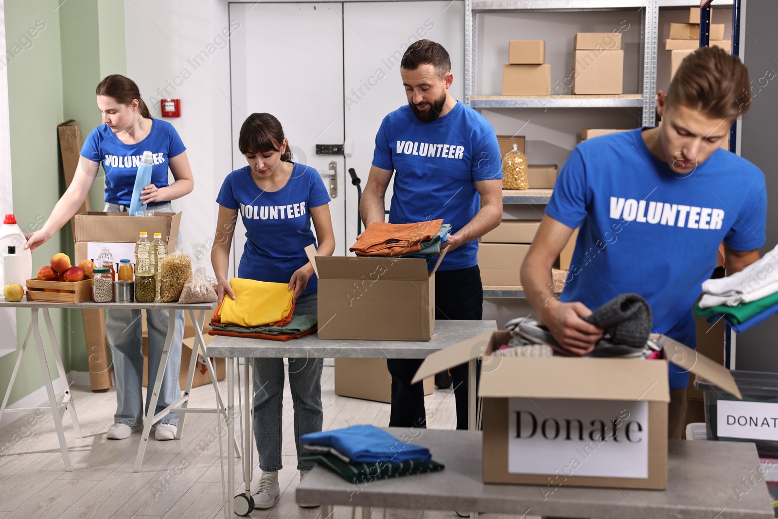 Photo of Group of volunteers packing donation goods at tables indoors