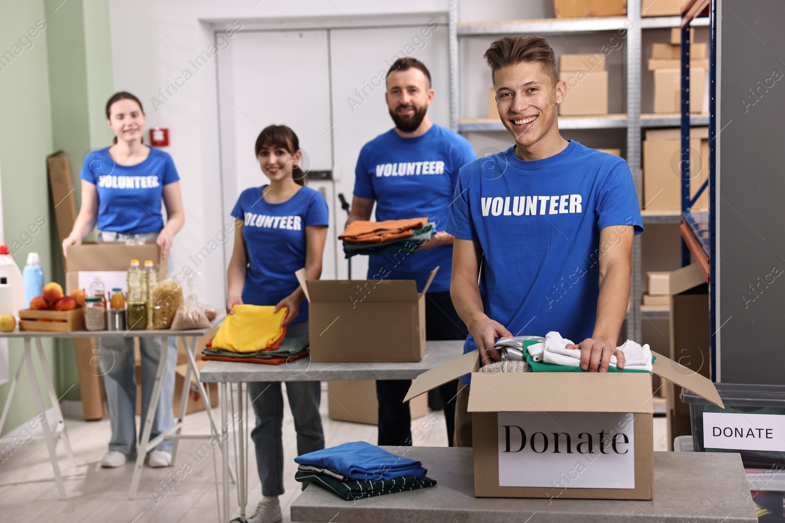 Photo of Group of volunteers packing donation goods at tables indoors