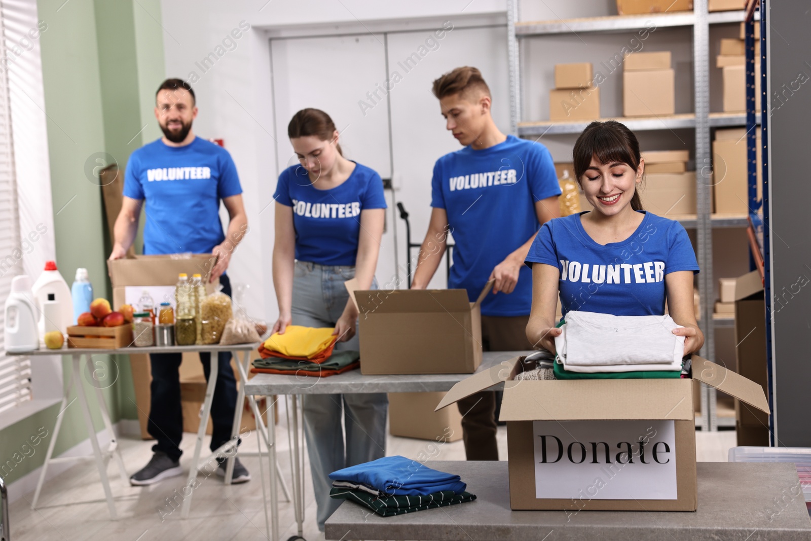 Photo of Group of volunteers packing donation goods at tables indoors