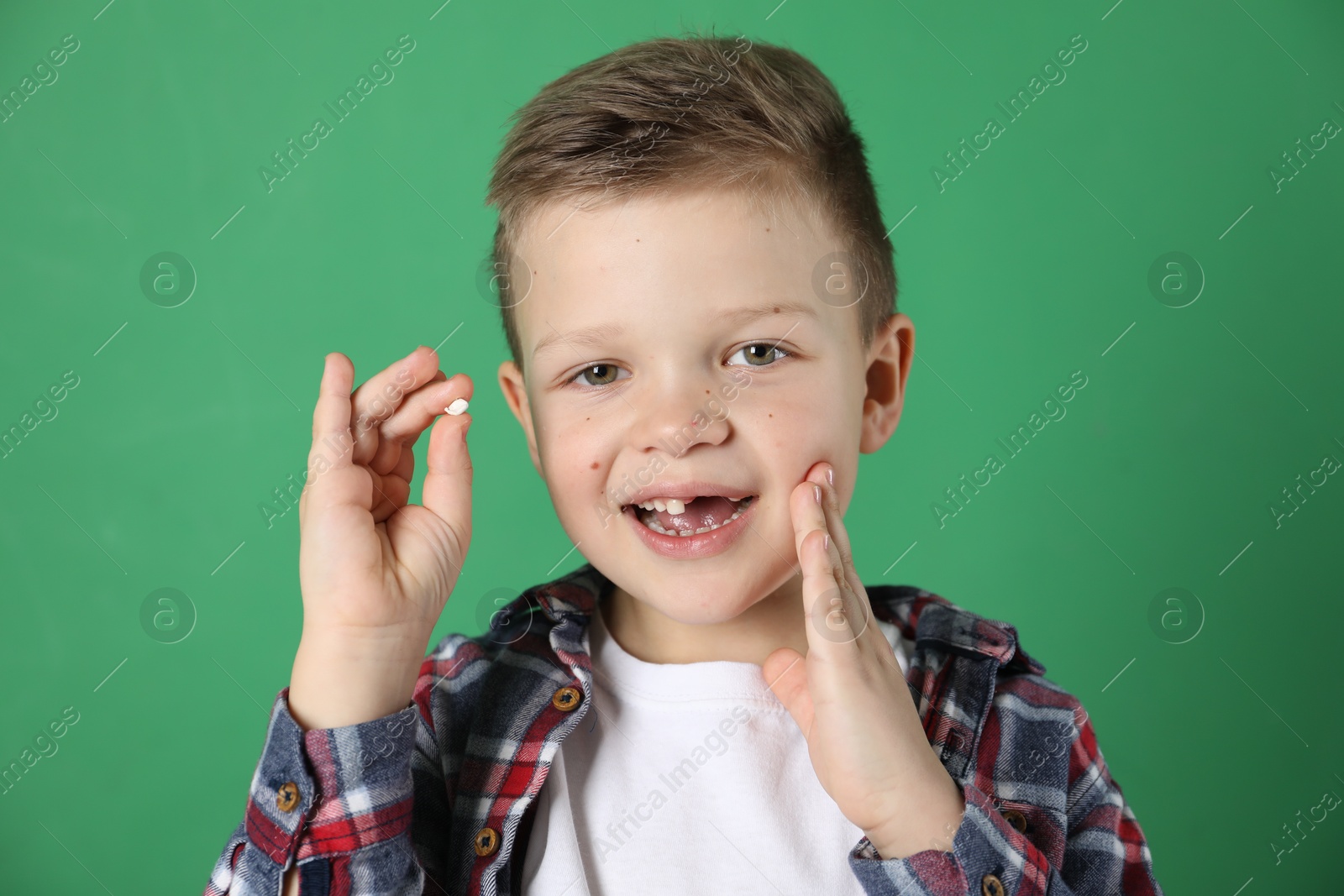 Photo of Cute little boy with missing tooth on green background. Waiting for tooth fairy