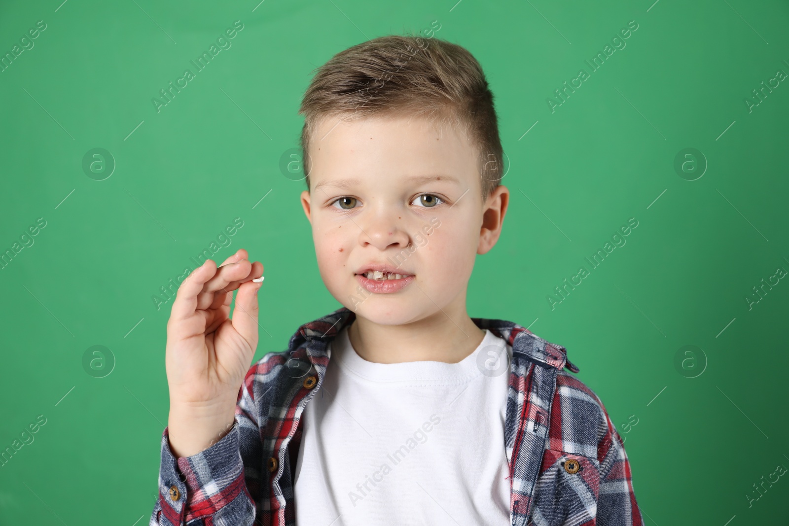 Photo of Cute little boy with missing tooth on green background. Waiting for tooth fairy