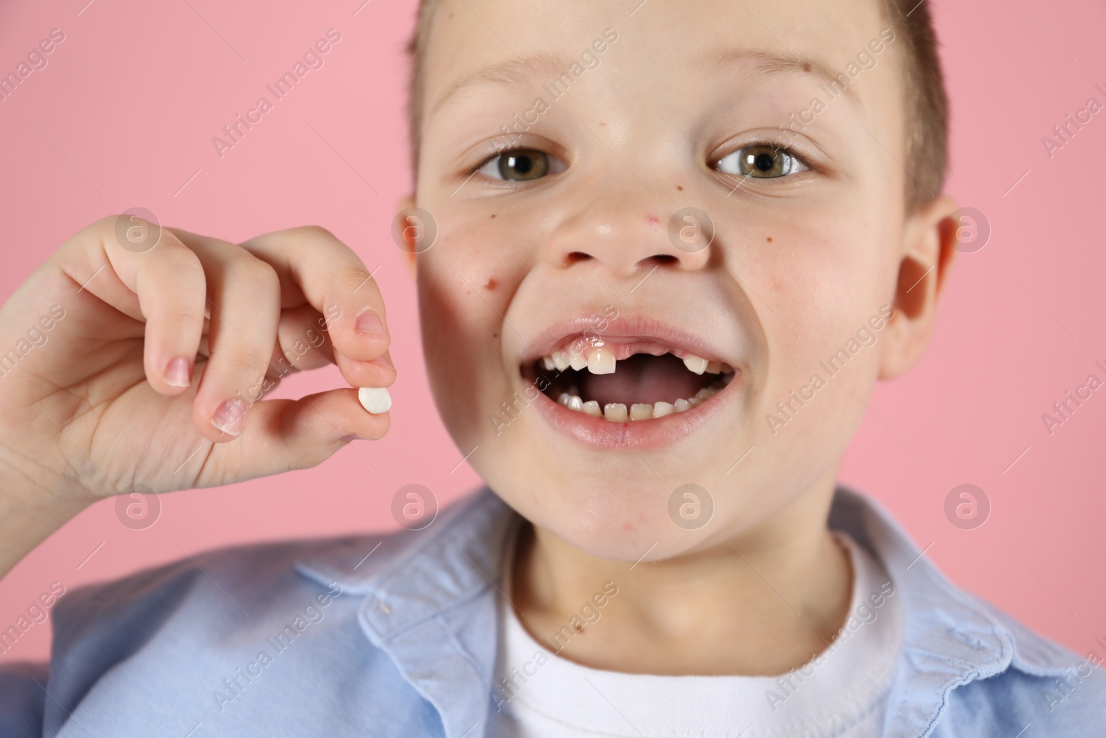 Photo of Cute little boy with missing tooth on pink background, closeup. Waiting for tooth fairy