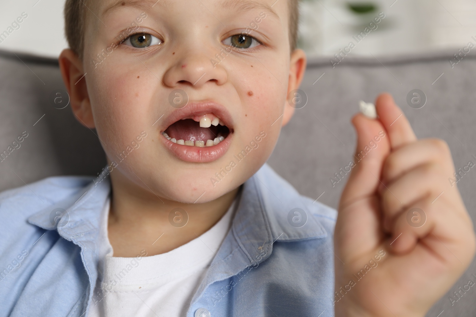 Photo of Cute little boy with missing tooth at home, closeup. Waiting for tooth fairy