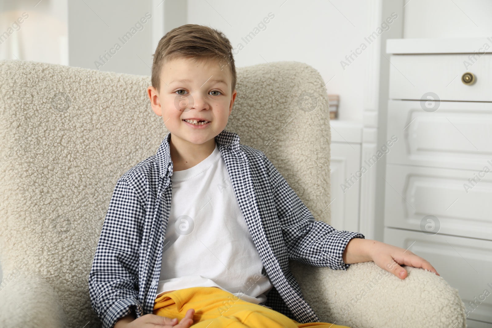 Photo of Cute little boy with missing tooth at home