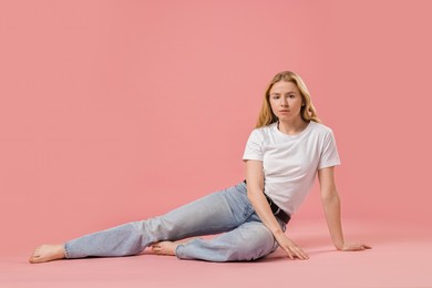 Photo of Woman in stylish jeans on pink background. Space for text