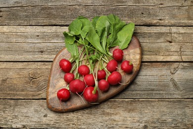 Photo of Many fresh radishes on wooden table, top view