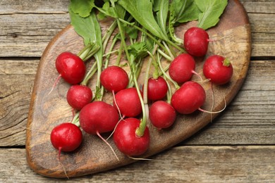 Photo of Many fresh radishes on wooden table, top view