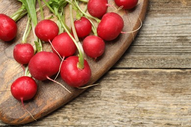 Photo of Many fresh radishes on wooden table, top view. Space for text
