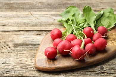 Photo of Many fresh radishes on wooden table, closeup. Space for text