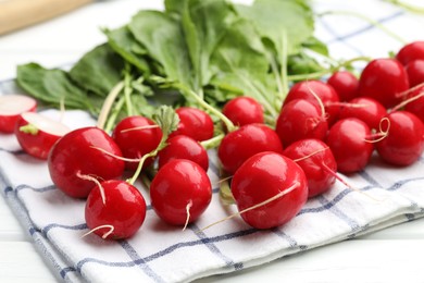 Photo of Many fresh radishes on white wooden table, closeup