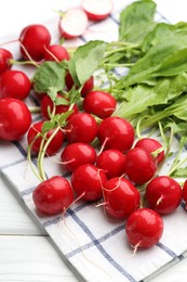 Photo of Many fresh radishes on white wooden table, closeup