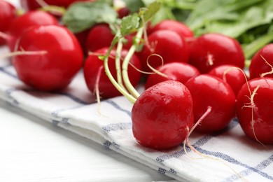 Photo of Many fresh radishes on white wooden table, closeup