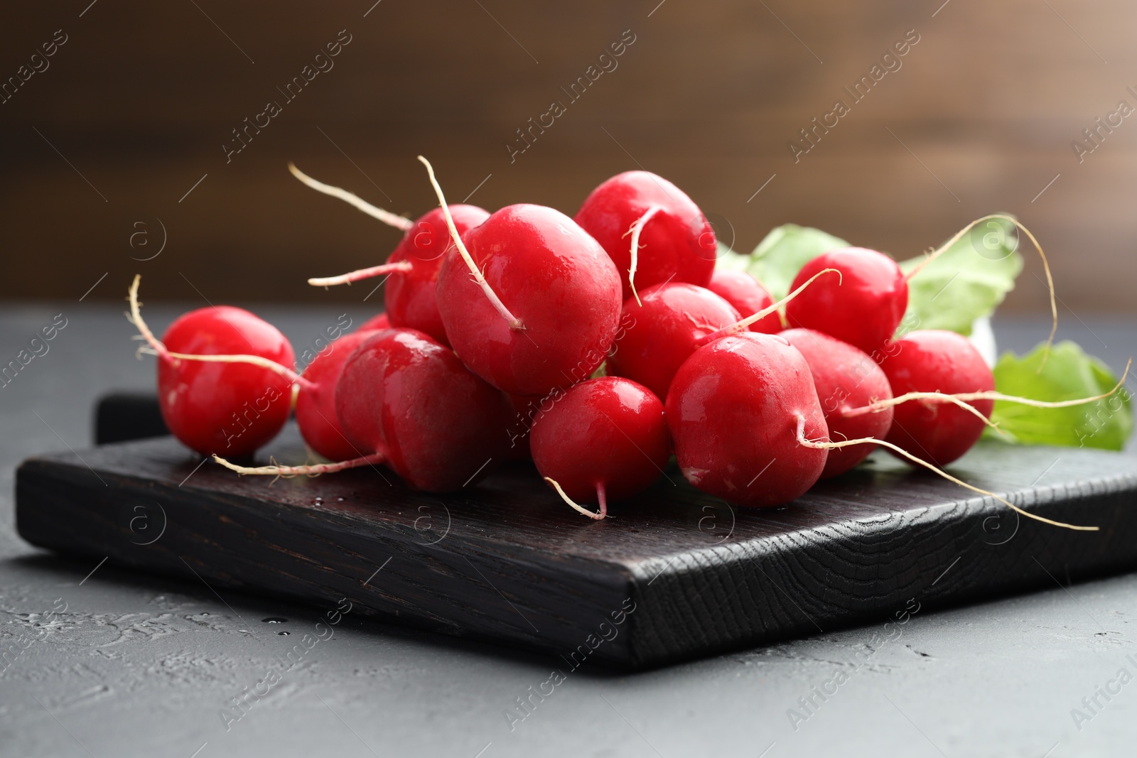 Many fresh radishes on dark textured table, closeup Photo of Many fresh radishes on dark textured table, closeup