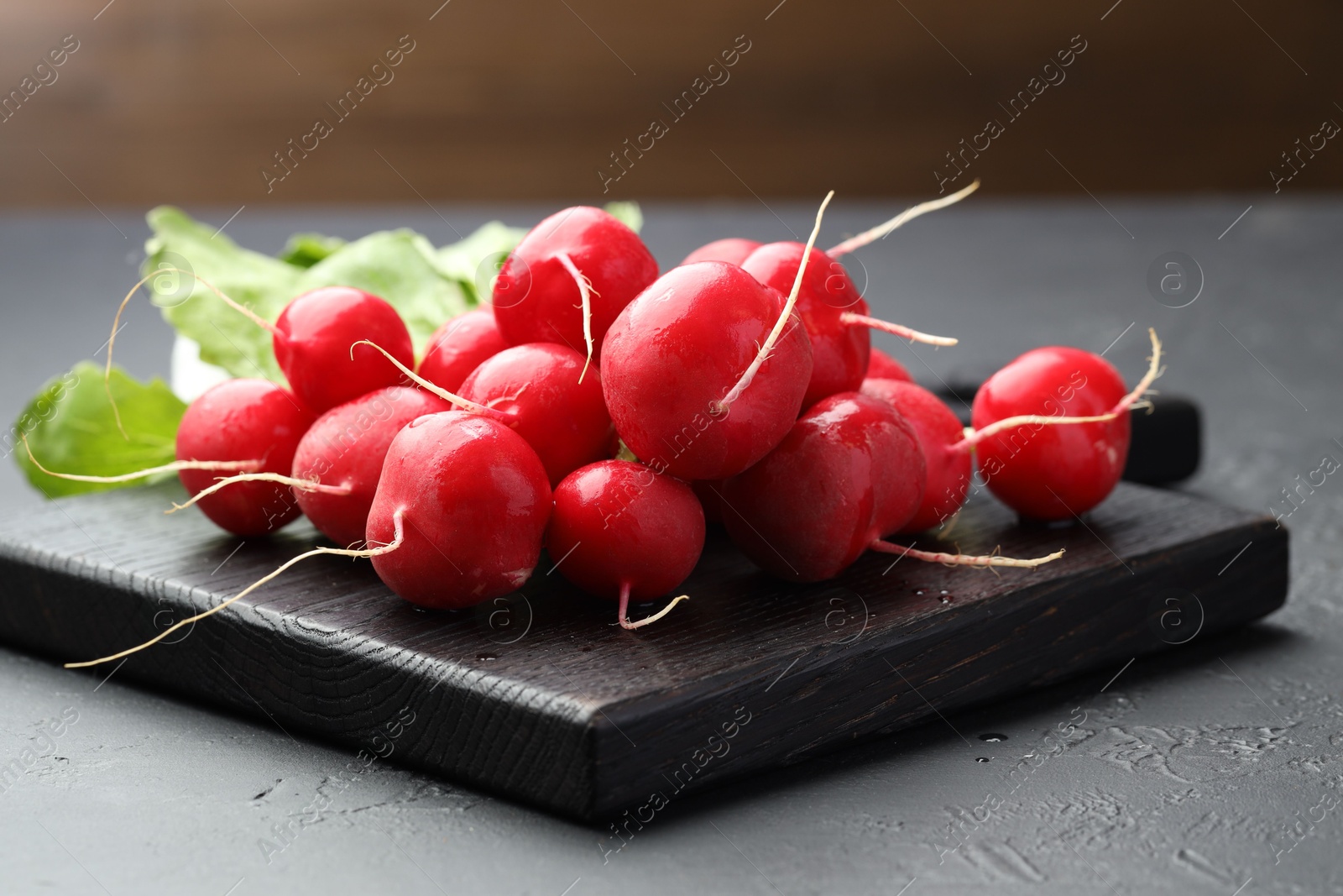 Many fresh radishes on dark textured table, closeup Photo of Many fresh radishes on dark textured table, closeup