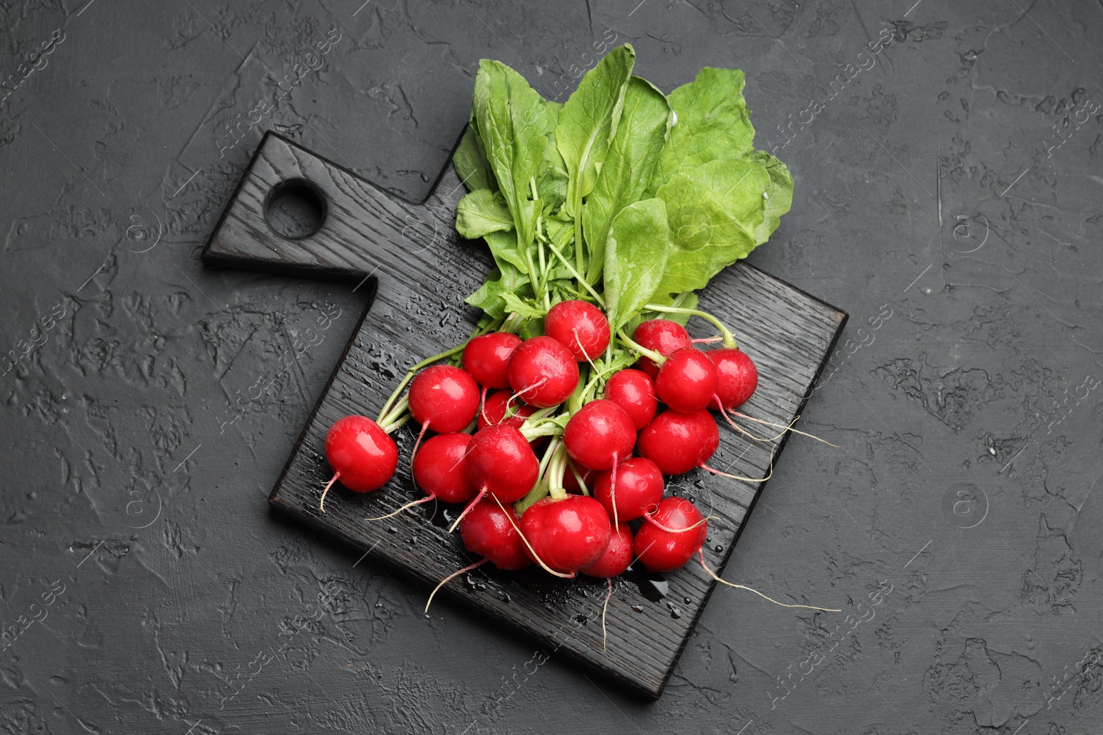 Many fresh radishes on dark textured table, top view Photo of Many fresh radishes on dark textured table, top view