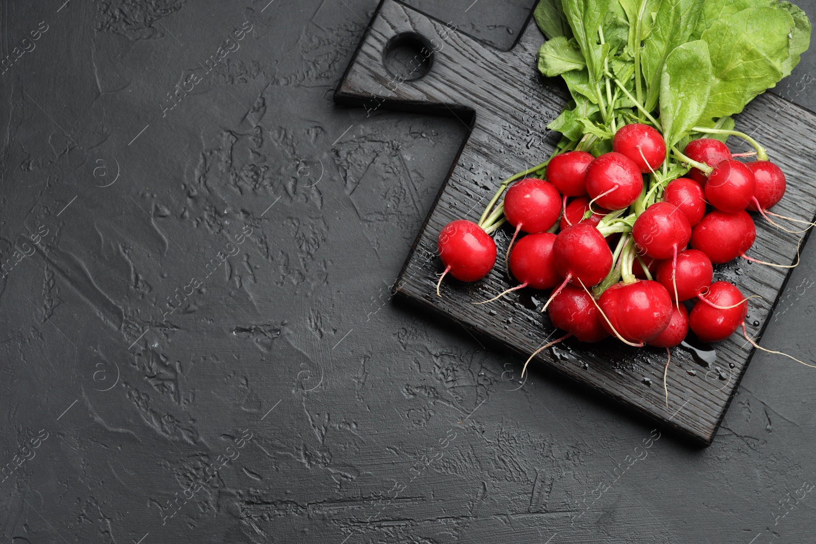 Many fresh radishes on dark textured table, top view. Space for text Photo of Many fresh radishes on dark textured table, top view. Space for text