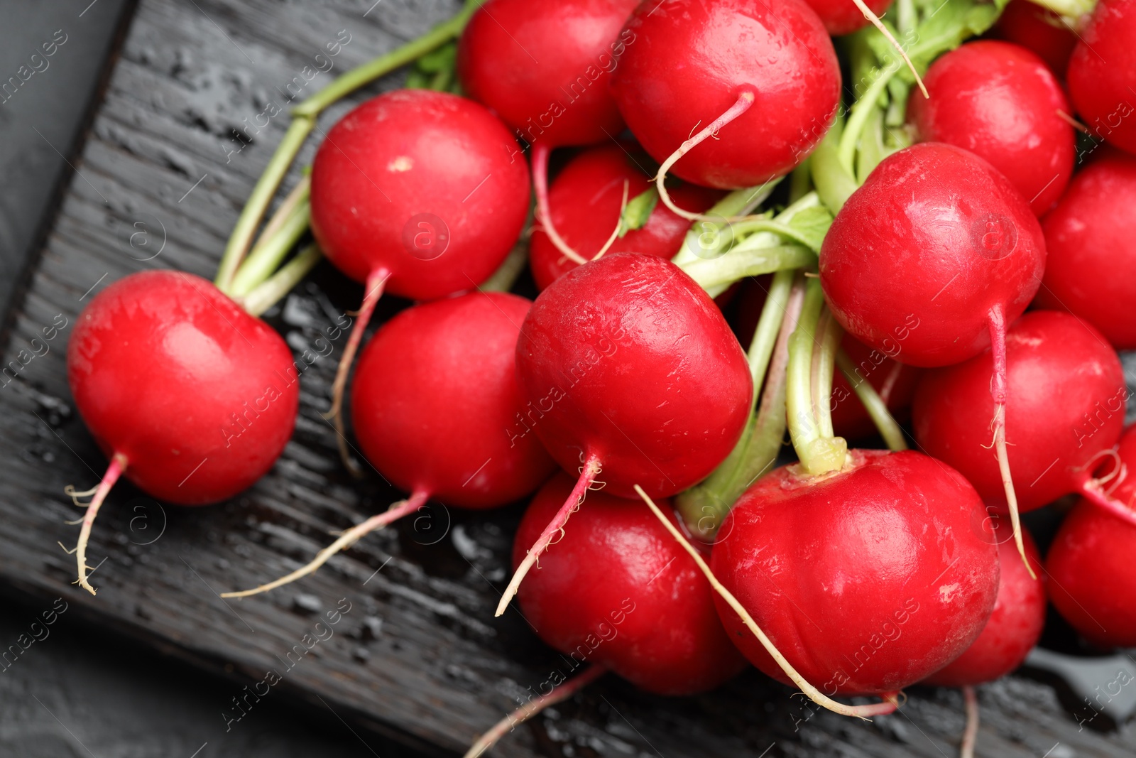Many fresh radishes on dark table, above view Photo of Many fresh radishes on dark table, above view