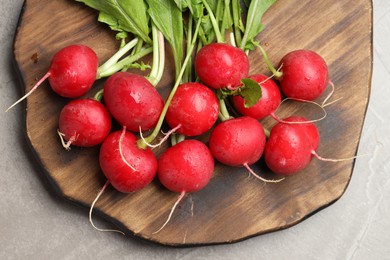 Photo of Many fresh radishes on grey textured table, top view
