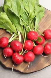 Photo of Many fresh radishes on grey textured table, top view
