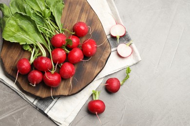 Photo of Many fresh radishes on grey textured table, flat lay. Space for text