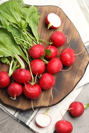 Photo of Many fresh radishes on grey textured table, flat lay