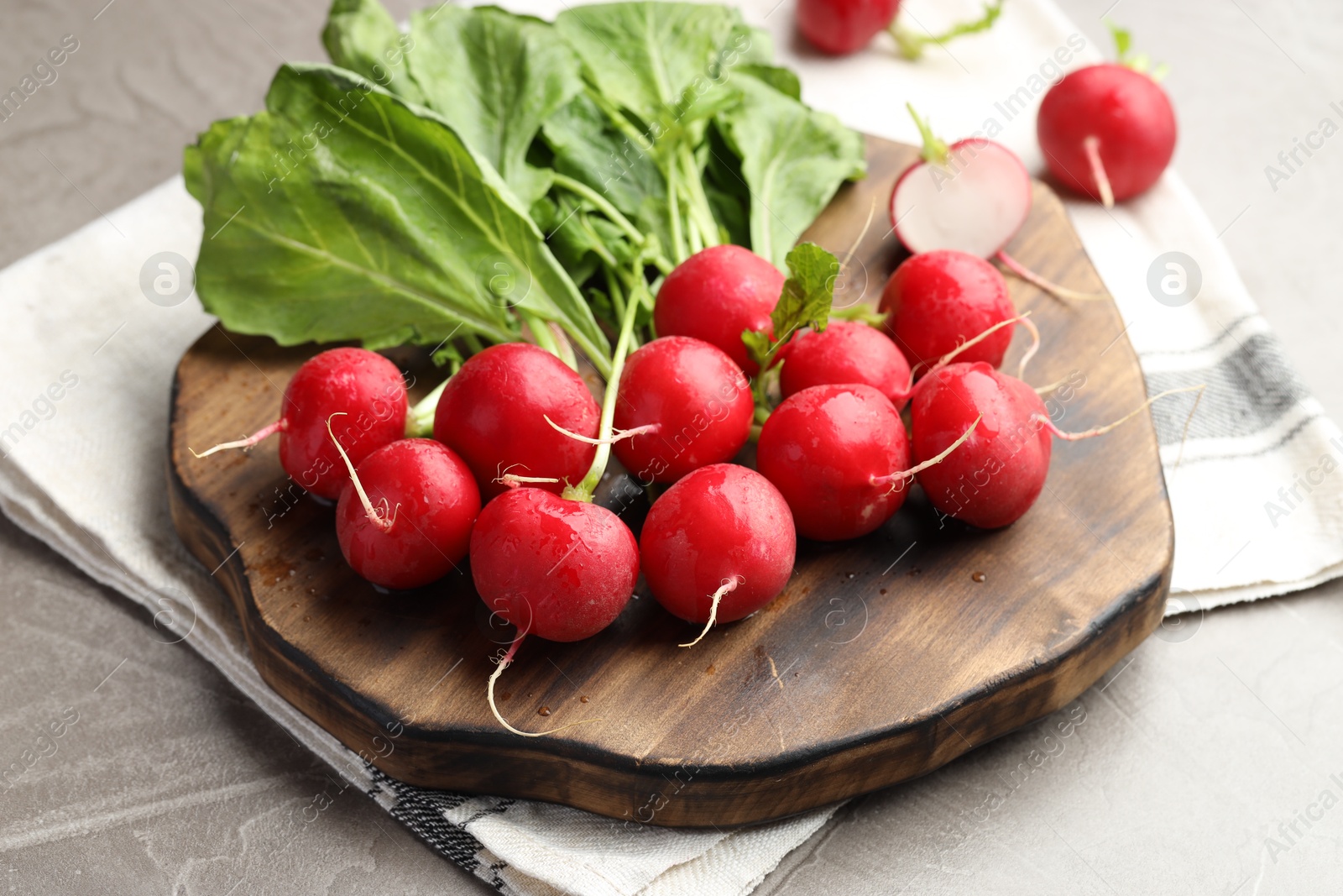 Many fresh radishes on grey textured table, closeup Photo of Many fresh radishes on grey textured table, closeup