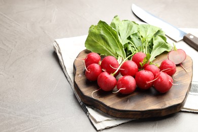 Photo of Many fresh radishes on grey textured table, closeup. Space for text