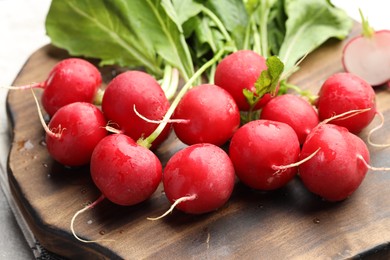 Photo of Many fresh radishes on grey table, closeup