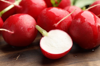 Photo of Many fresh radishes on wooden table, closeup
