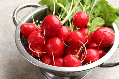 Photo of Many fresh radishes on grey textured table, closeup