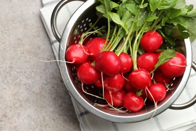 Photo of Many fresh radishes on grey textured table, top view. Space for text