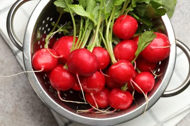 Photo of Many fresh radishes on grey textured table, top view