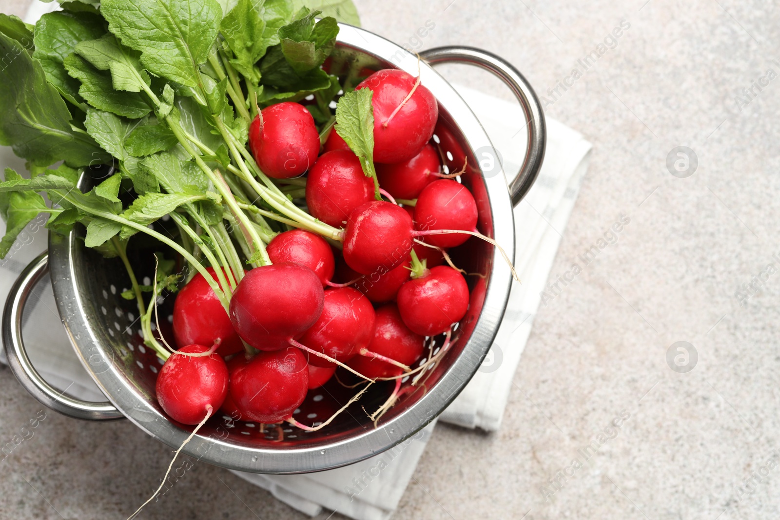 Photo of Many fresh radishes on grey textured table, top view. Space for text
