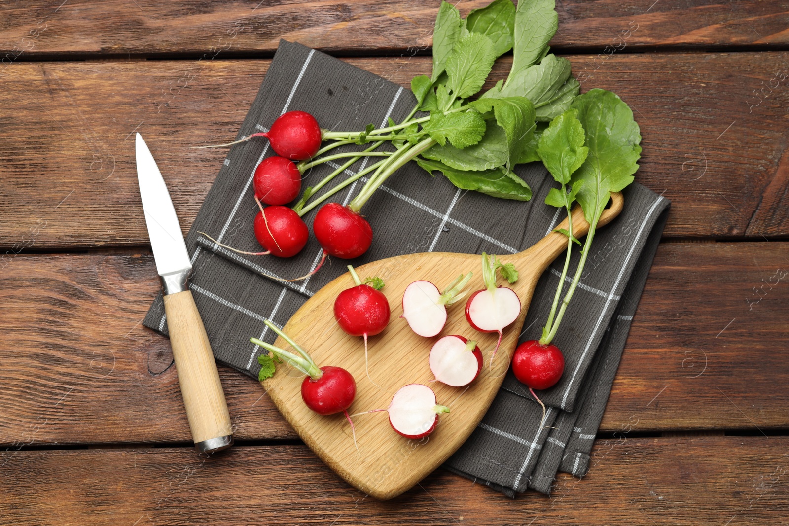 Photo of Many fresh radishes and knife on wooden table, flat lay