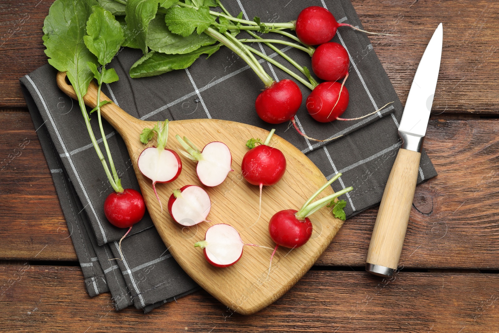 Photo of Many fresh radishes and knife on wooden table, flat lay