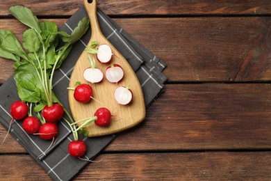 Photo of Many fresh radishes on wooden table, top view. Space for text