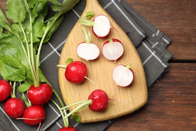 Photo of Many fresh radishes on wooden table, top view