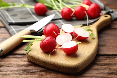 Photo of Many fresh radishes on wooden table, closeup