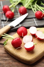 Photo of Many fresh radishes on wooden table, closeup