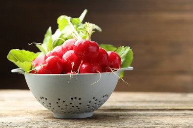 Photo of Many fresh radishes on wooden table, closeup. Space for text