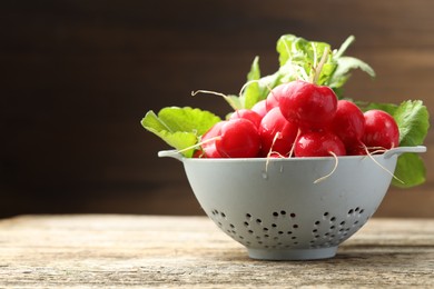 Photo of Many fresh radishes on wooden table, closeup. Space for text