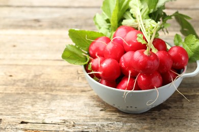 Photo of Many fresh radishes on wooden table, closeup. Space for text