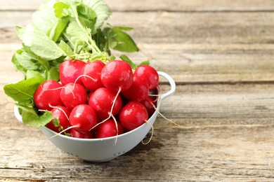 Photo of Many fresh radishes on wooden table, closeup. Space for text