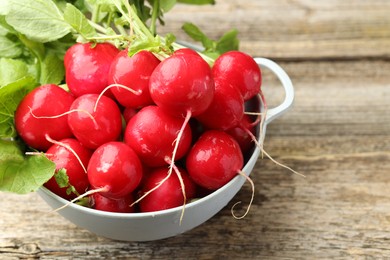 Photo of Many fresh radishes on wooden table, closeup. Space for text