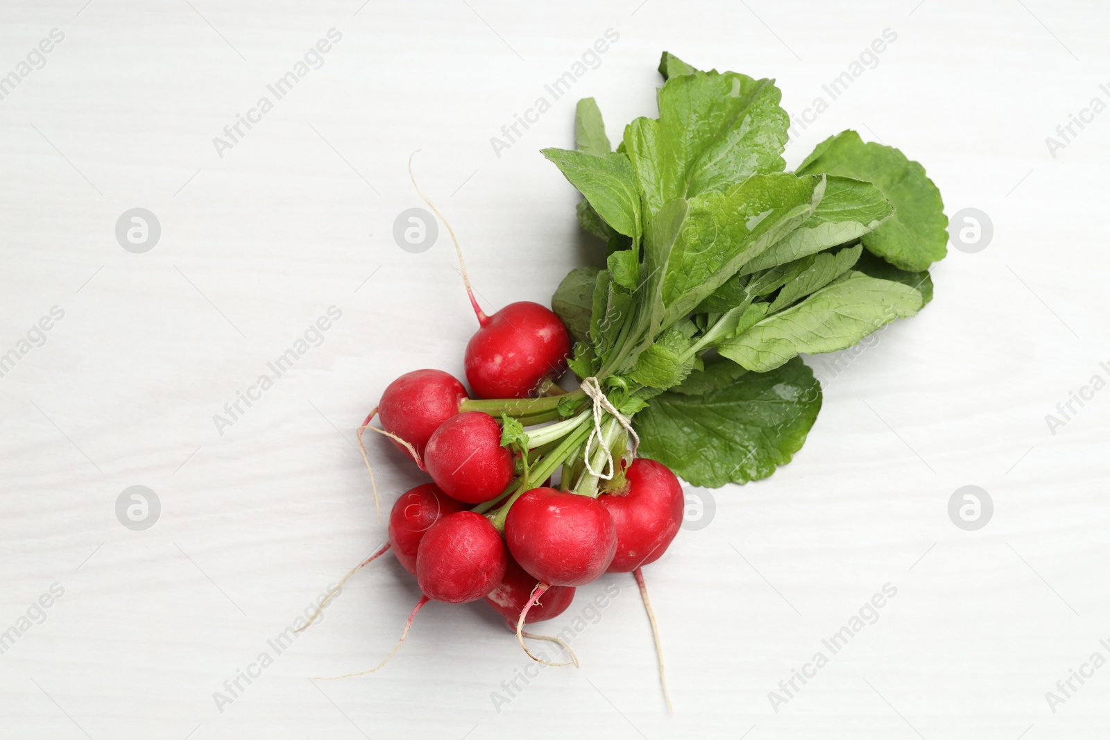 Bunch of fresh radishes on white wooden table, top view Photo of Bunch of fresh radishes on white wooden table, top view