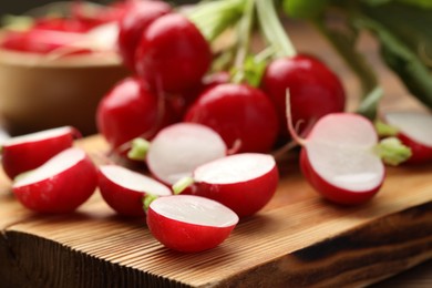 Photo of Fresh cut radishes on wooden board, closeup